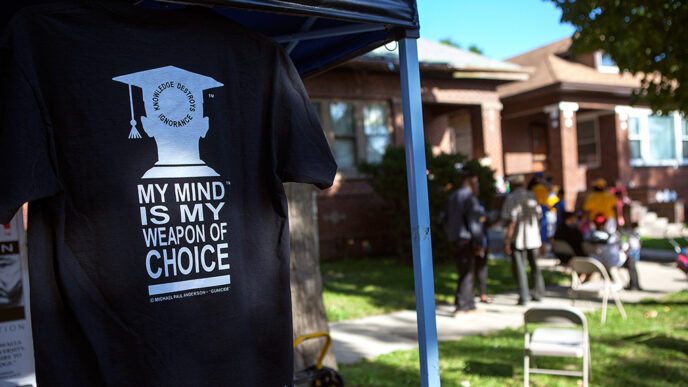 A t-shirt reading My Mind is My Weapon of Choice hangs from a tent. In the background.