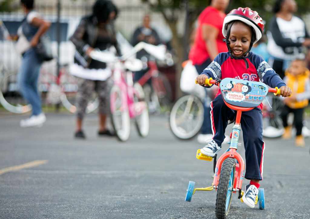 A young boy in a helmet tests out a new bicycle